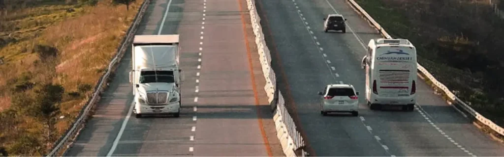 a highway with a cargo truck and some other vehicles